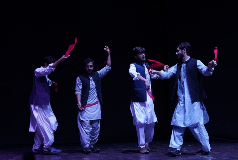 KDC performers on stage with red scarves